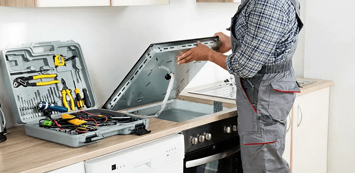 Handyman repairing a cooktop and checking wiring connections in Rochester, NY
