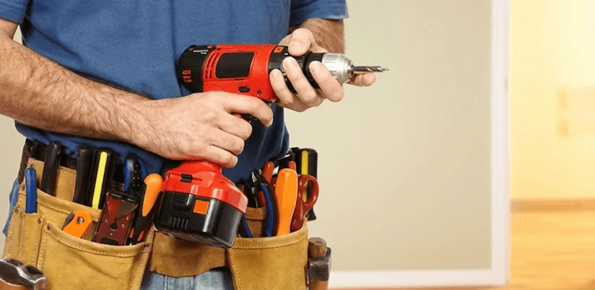 Handyman holding a power drill for home repairs and installations in Rochester, NY